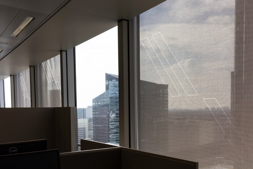 View of a bay window with several roller blinds 